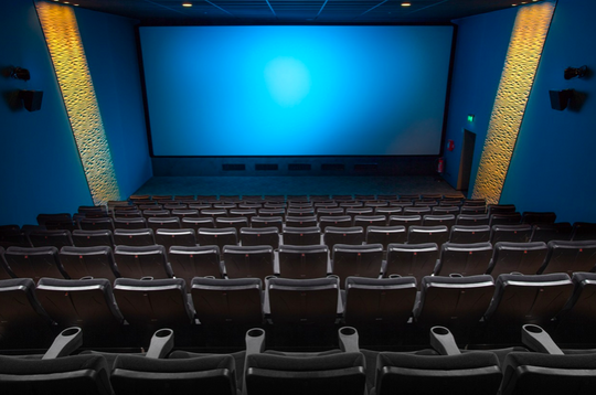 Stuhlreihen in einem leeren Kinosaal.