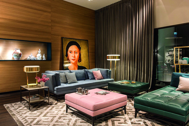 Das modulare Sitzmöbel-Ensemble, bestehend aus zwei- und dreisitzer-Sofa, Recamiere und Pouf kann einzeln oder in verschiedensten Variationen arrangiert werden. Das elegante Holzgestell aus dunkel gebeizter Eiche mit Porzellanplatte verleiht dem Sofa eine moderne Leichtigkeit. Die aufwendige Polsterung steht für höchsten Sitzkomfort. Das Möbel kann individuell mit den luxuriösen Stoffen aus der gesamten MEISSEN COUTURE® Stoff-Kollektion bezogen werden. Bei dem großen Wandbild aus Meißner Porzellan handelt es sich um einen Ausschnitt aus Antonio Donghis „Donna al caffe“ (1931). 