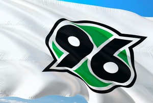 Flagge von Hannover 96. Flagge des Fußballclubs Hannover 96 vor blauem Hintergrund.